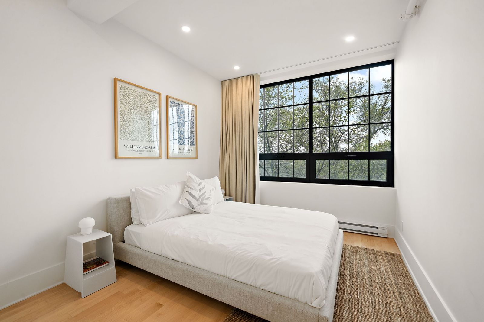 Calm bedroom with framed prints and a large window