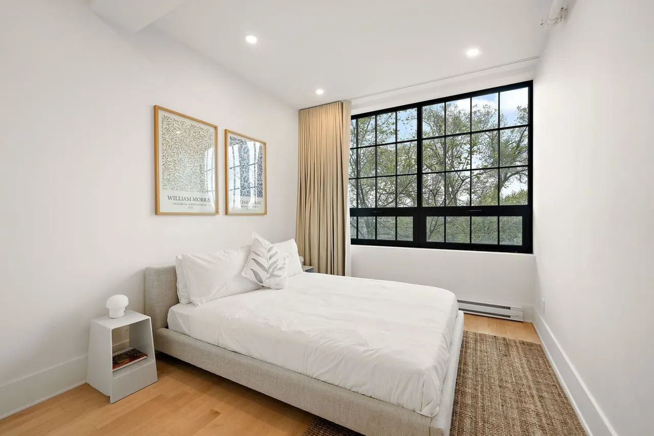 Calm bedroom with framed prints and a large window