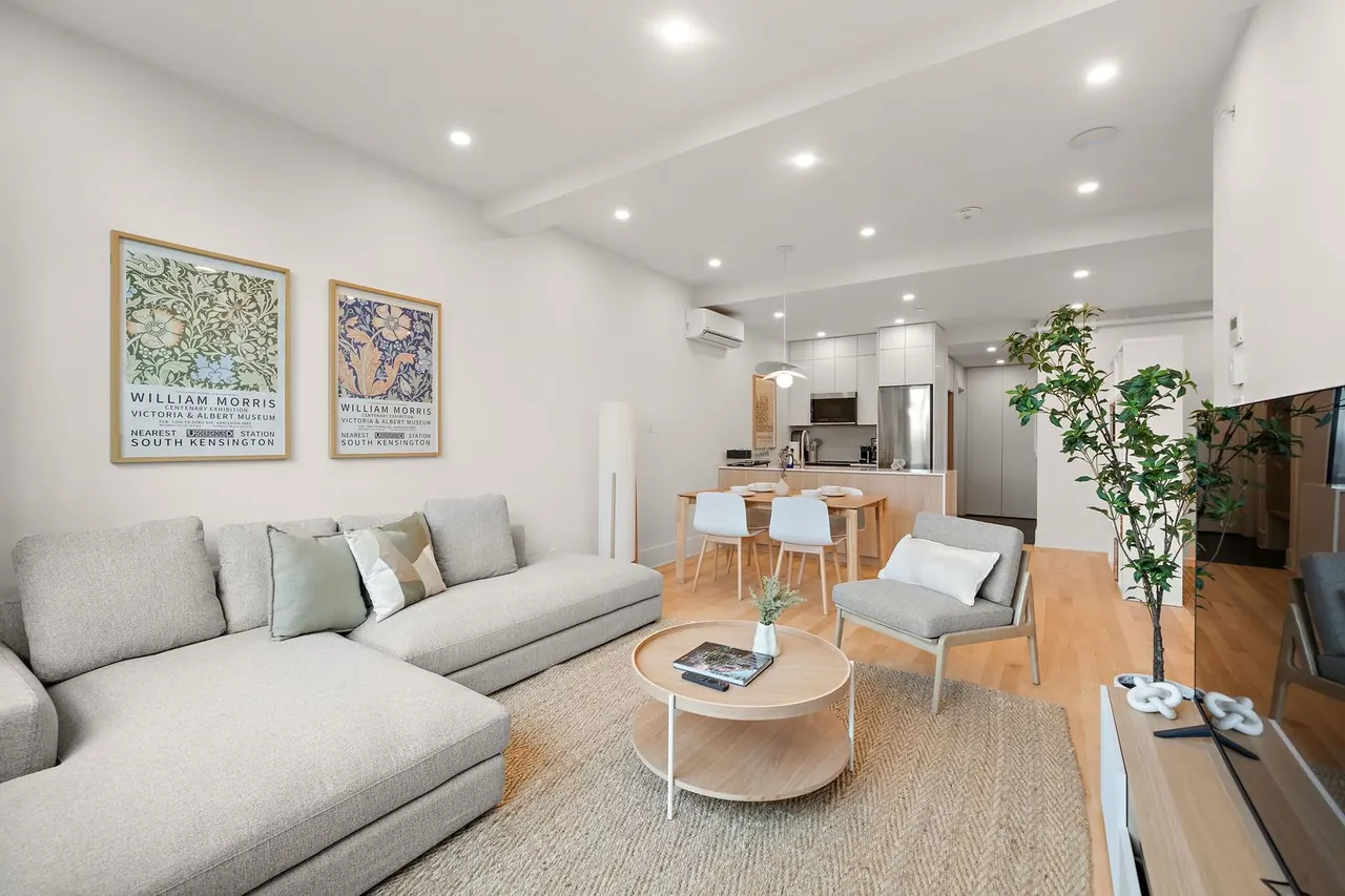 Living room with sectional sofa, round coffee table and kitchen beyond